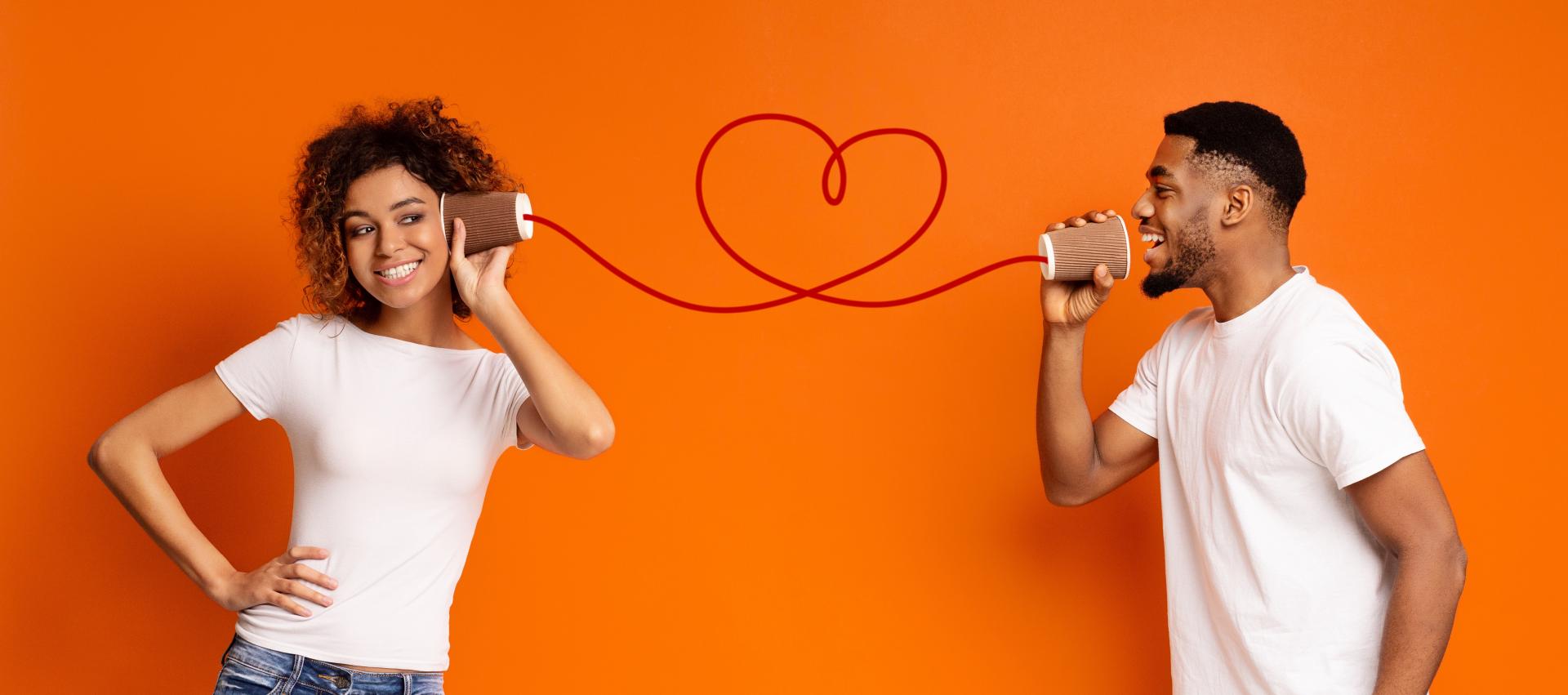 A playful couple connecting with cup phones