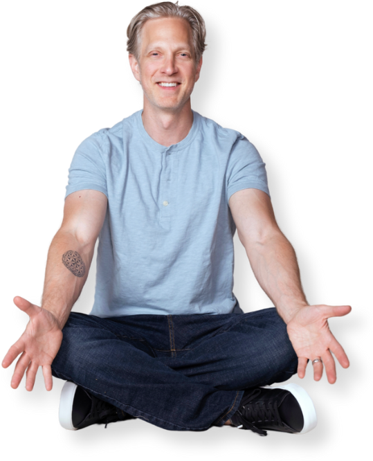 Randy Spelling seated with arms extended out and open smiling