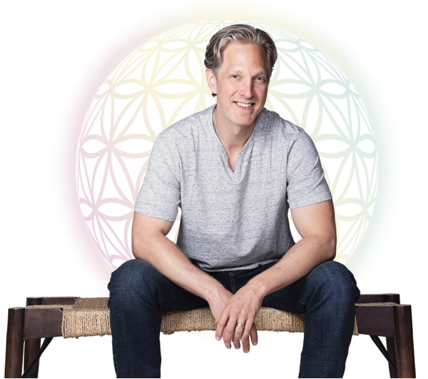 Randy Spelling seated on a bench leaning over smiling with hands crossed