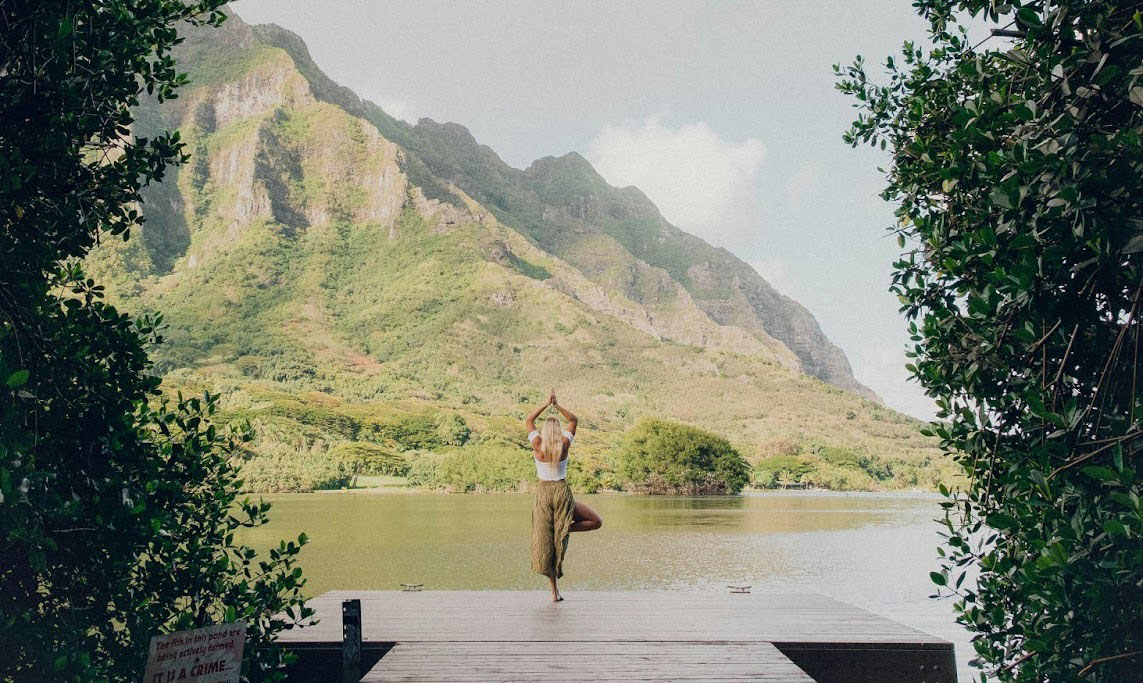 Woman doing yoga in nature, self-regulating and grounding herself.