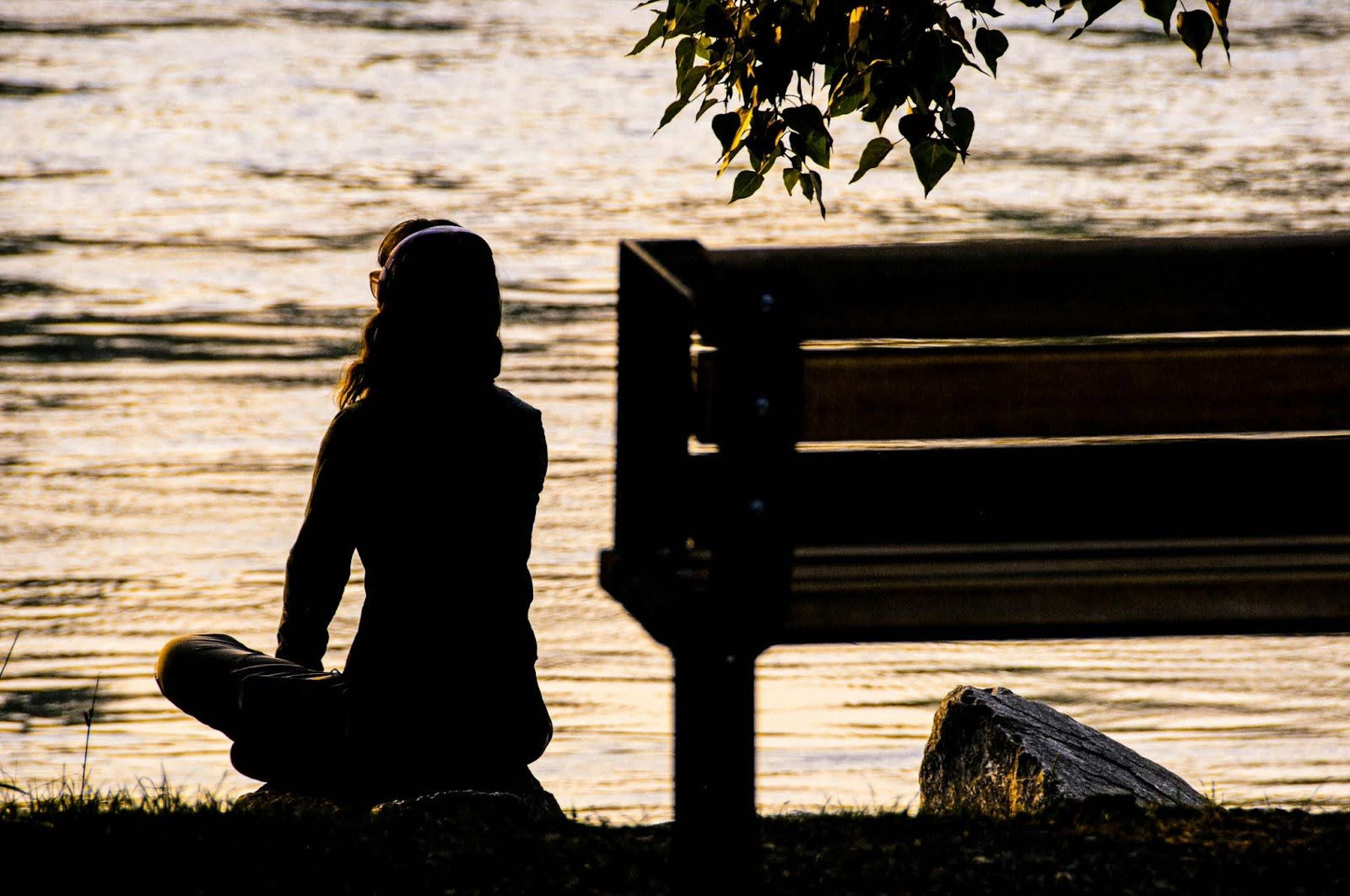 A girl by the river, doing meditation for personal growth and self-discovery.