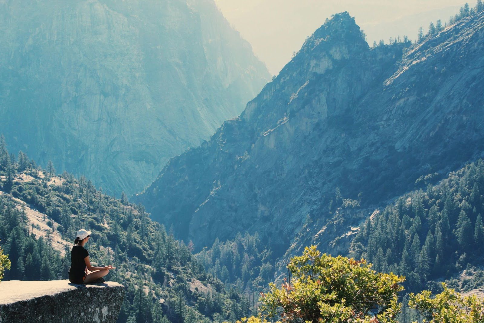 Person meditates atop of a mountain, grounded in his body.