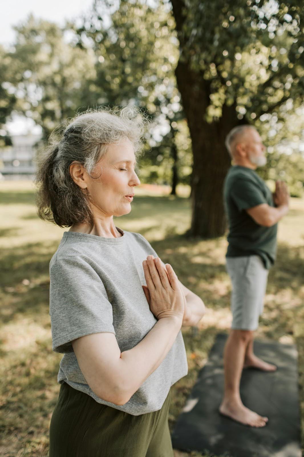 Woman and man doing yoga in nature, illustrating self-regulation and mindful breathing