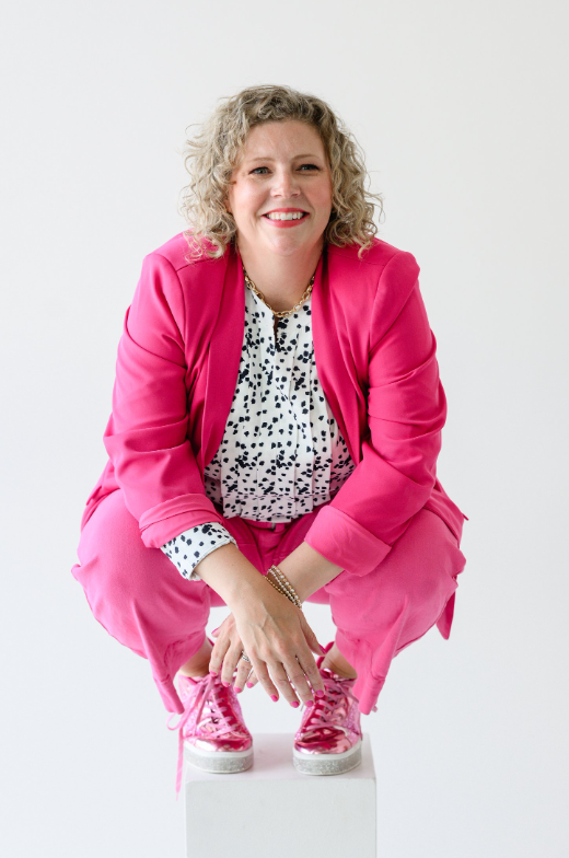 Sarah A. Jacobson, Fractional COO and client-delivery strategist, smiling in pink suit