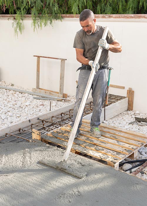 Worker in grey clothes spreading concrete