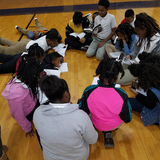 students reading in gym