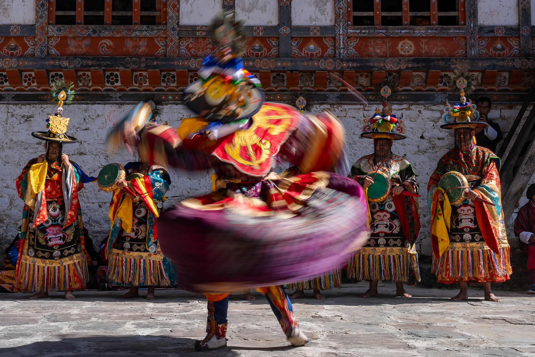 Capturing motion blur of colorful masked dancer at Prakar festival, Bhutan - Raw Tours experience.