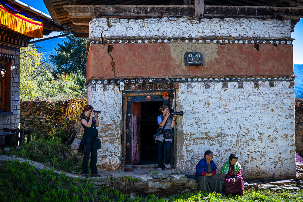 Colorful masked dancers performing at a traditional Bhutanese festival - Raw Tours cultural experience.