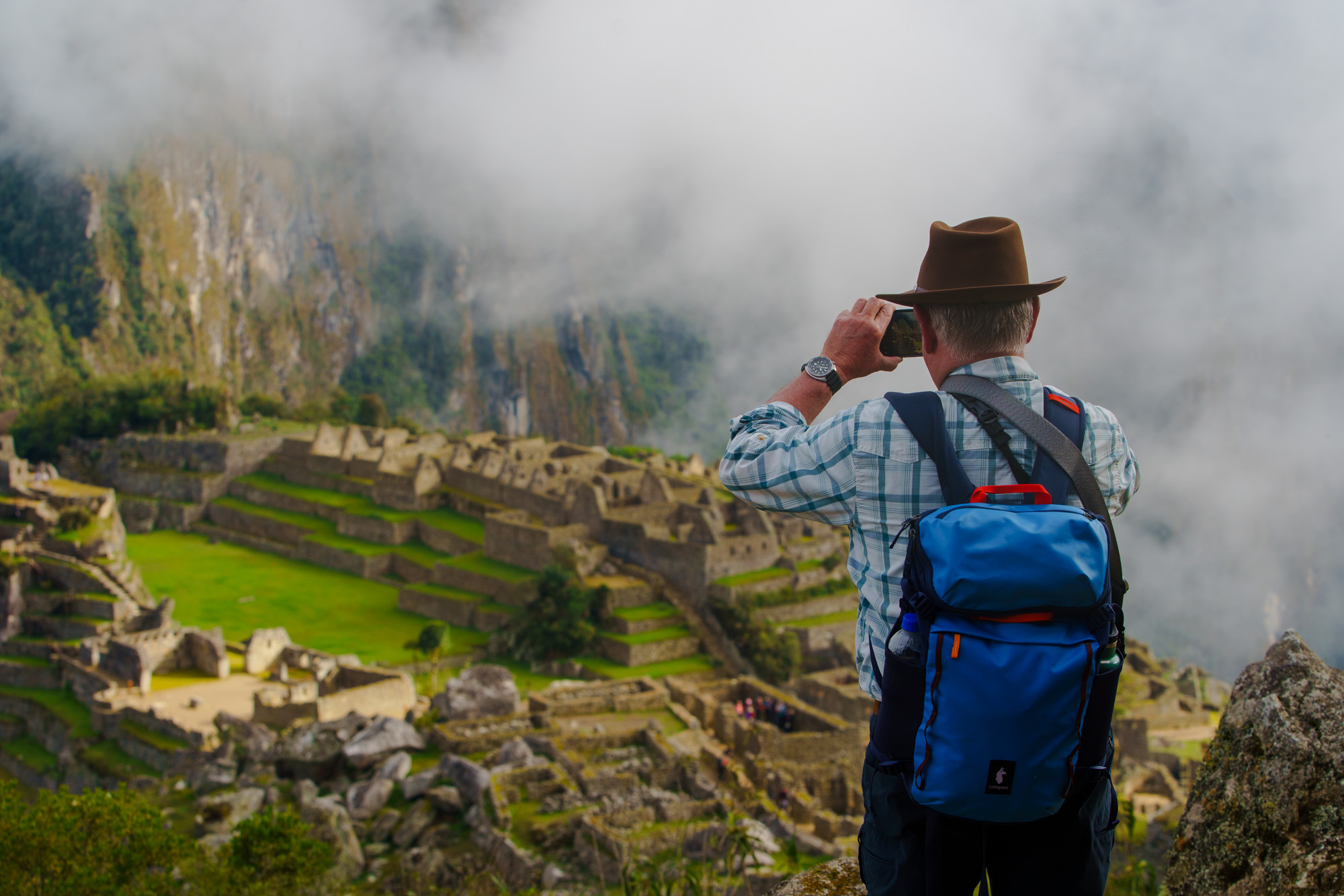 Photographer overlooking misty Machu Picchu ruins during Raw Tours Peru photo tour