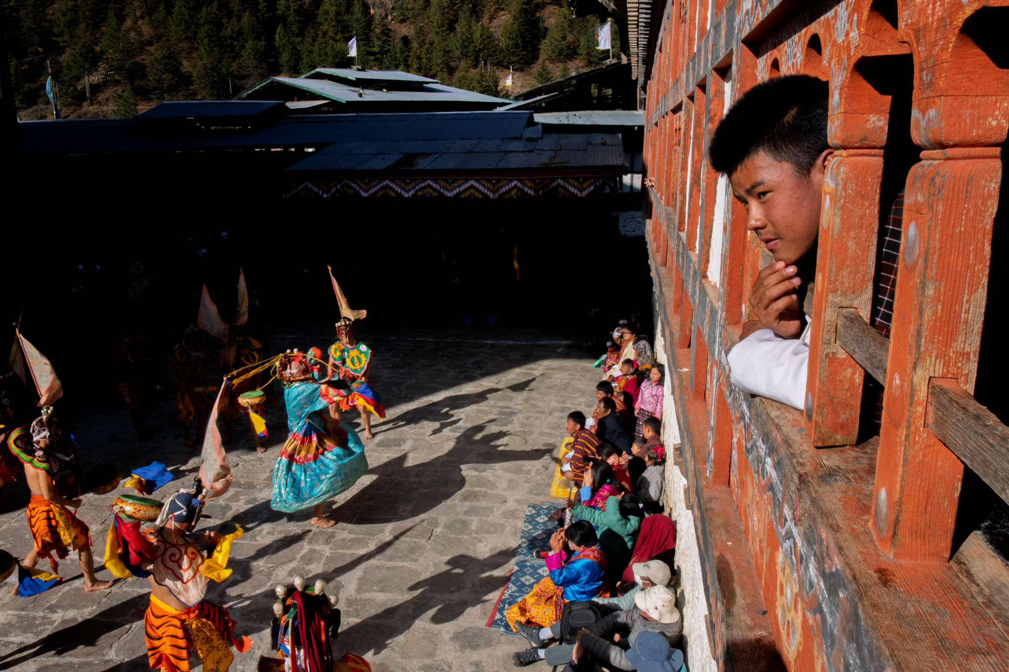 Unique perspective watching Prakar festival dancers in Bhutan from inside a building - Raw Tours photo opportunity.