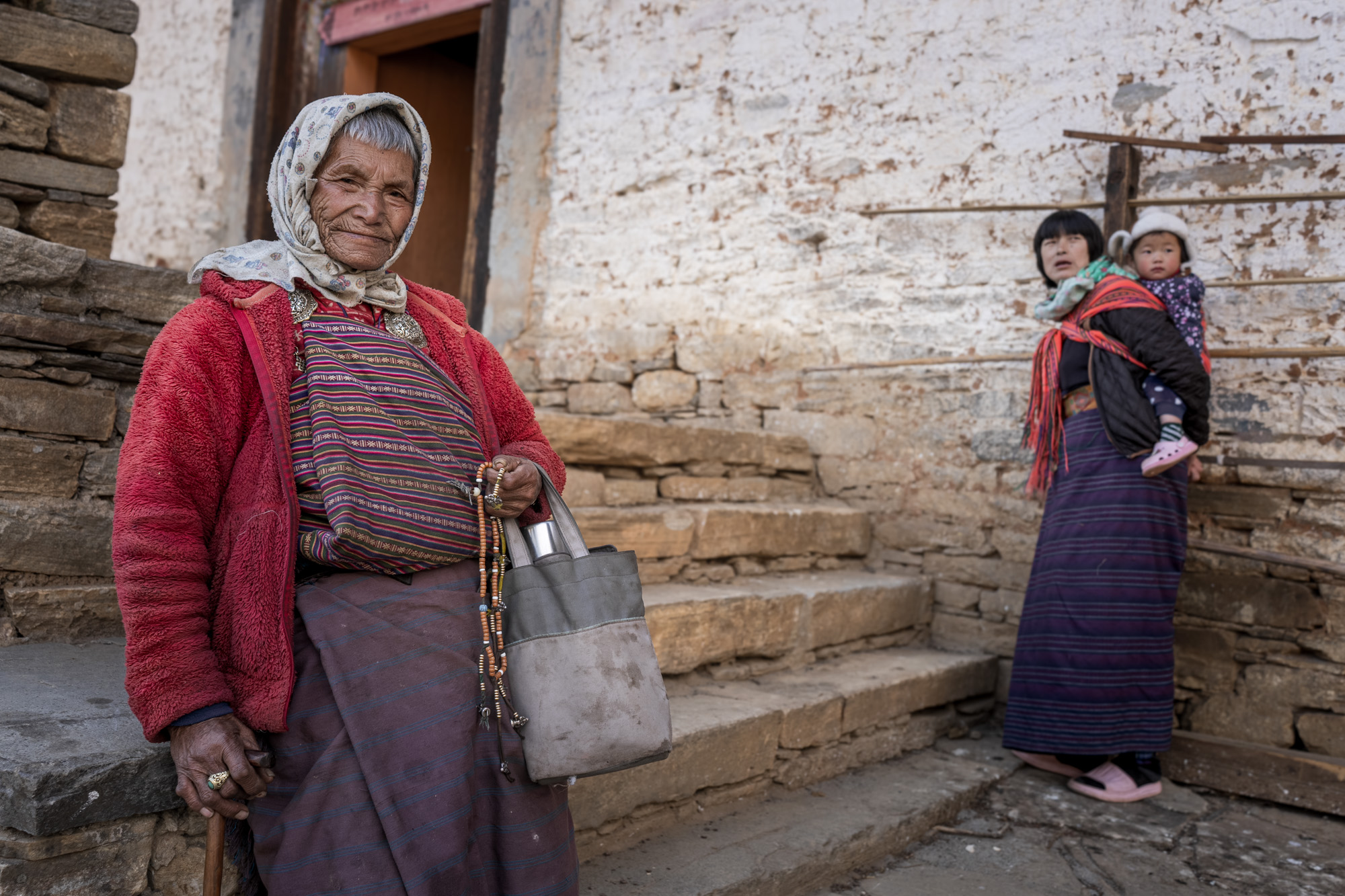 Portrait of smiling elderly Bhutanese woman in traditional attire - captured with Raw Tours.