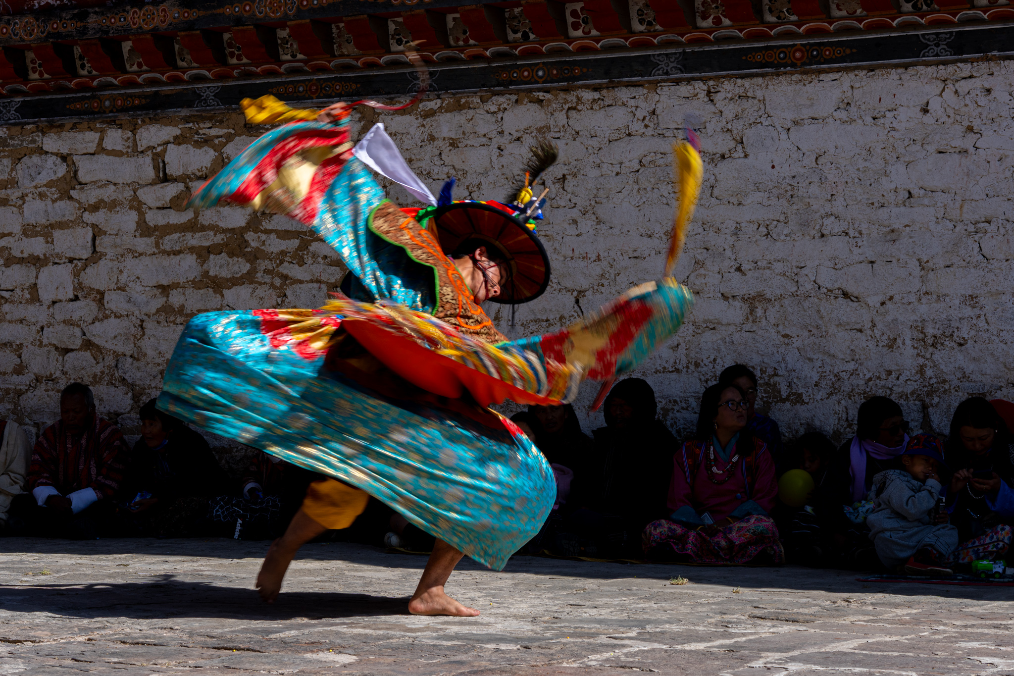 Colorful masked dancers performing at a traditional Bhutanese festival - Raw Tours cultural experience.