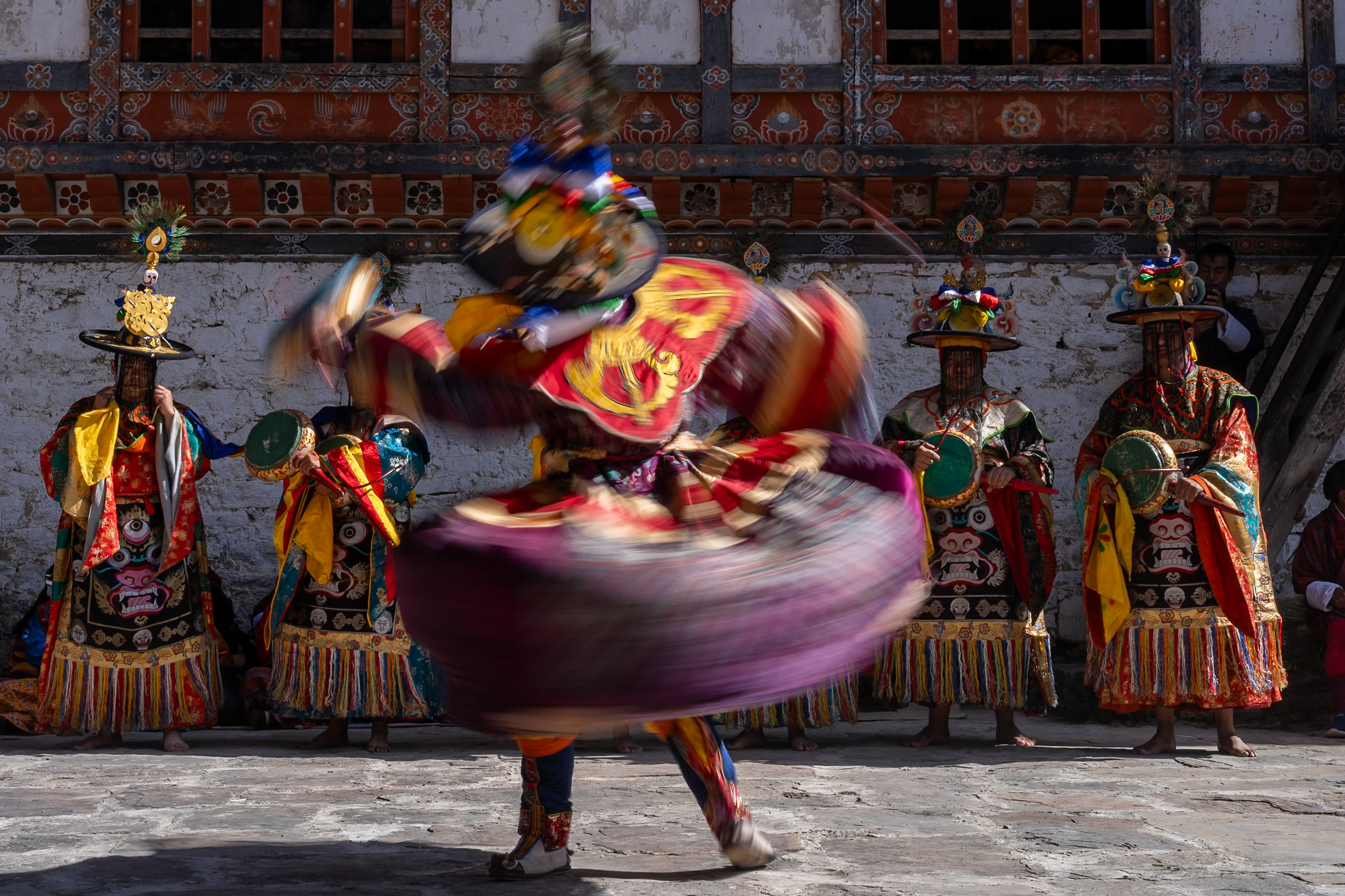 Bhutanese festival dancer spinning in colorful traditional costume - a destination offered by Raw Tours