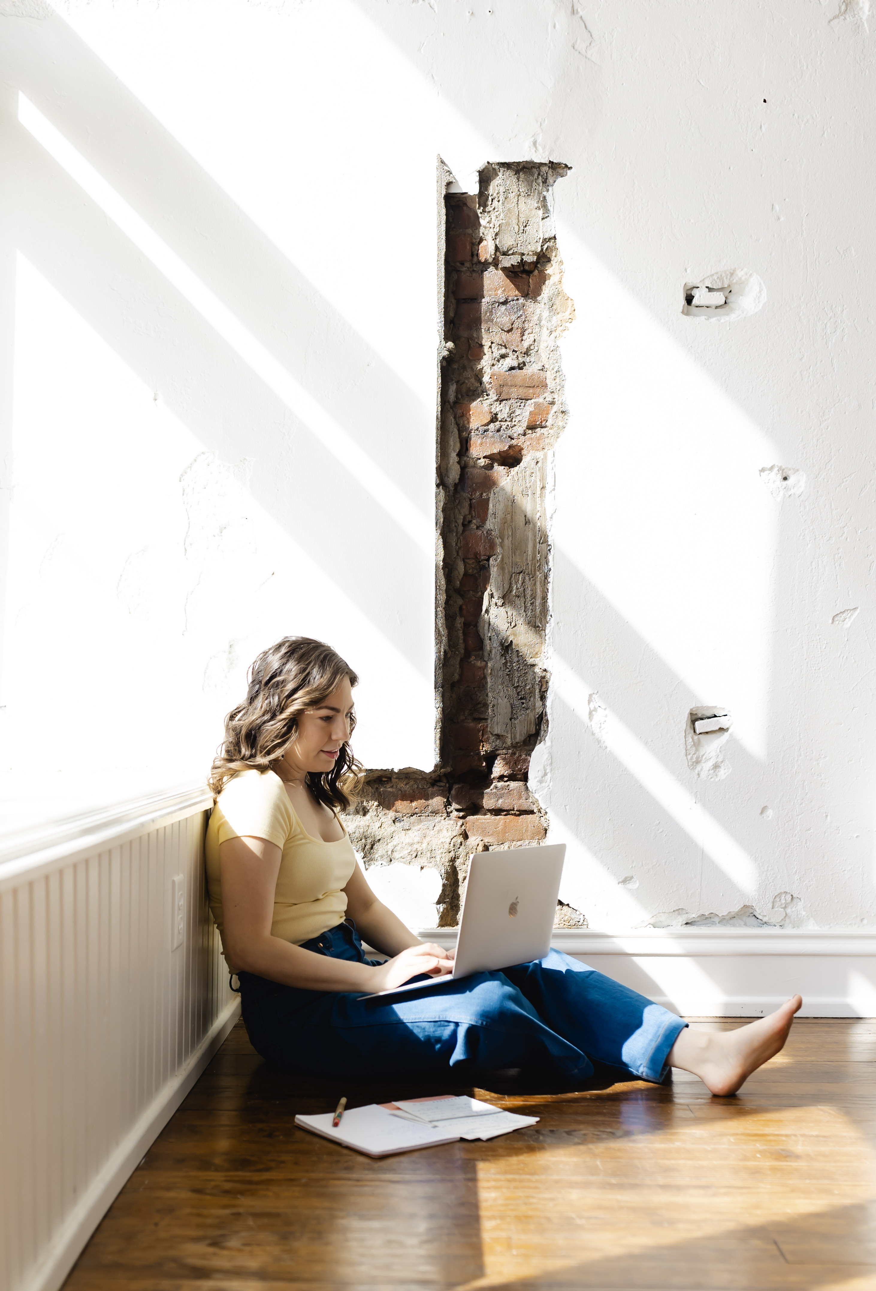 Johanna sits on a studio floor with her laptop on her lap