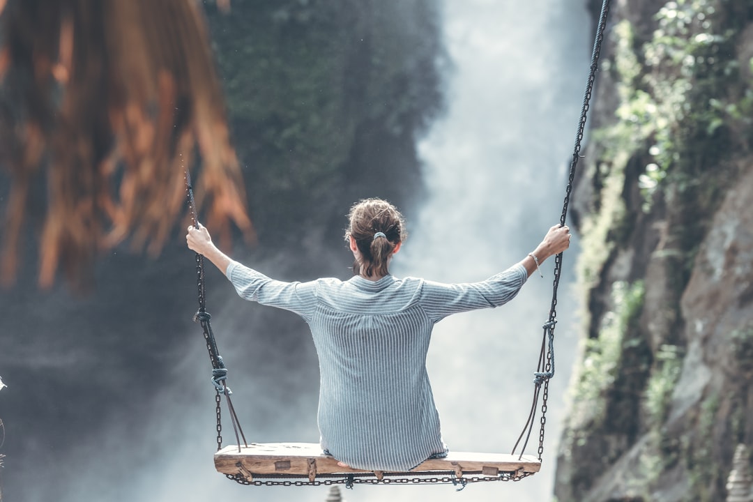 woman in a swing in front of waterfall -hormone reset