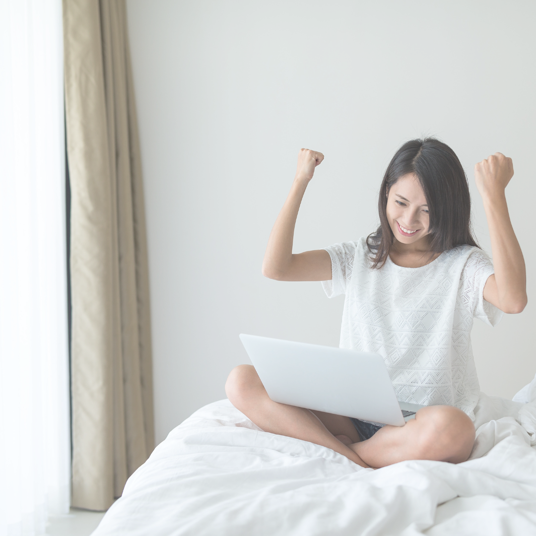 A woman sitting in her home empowered by what she wrote using her laptop.
