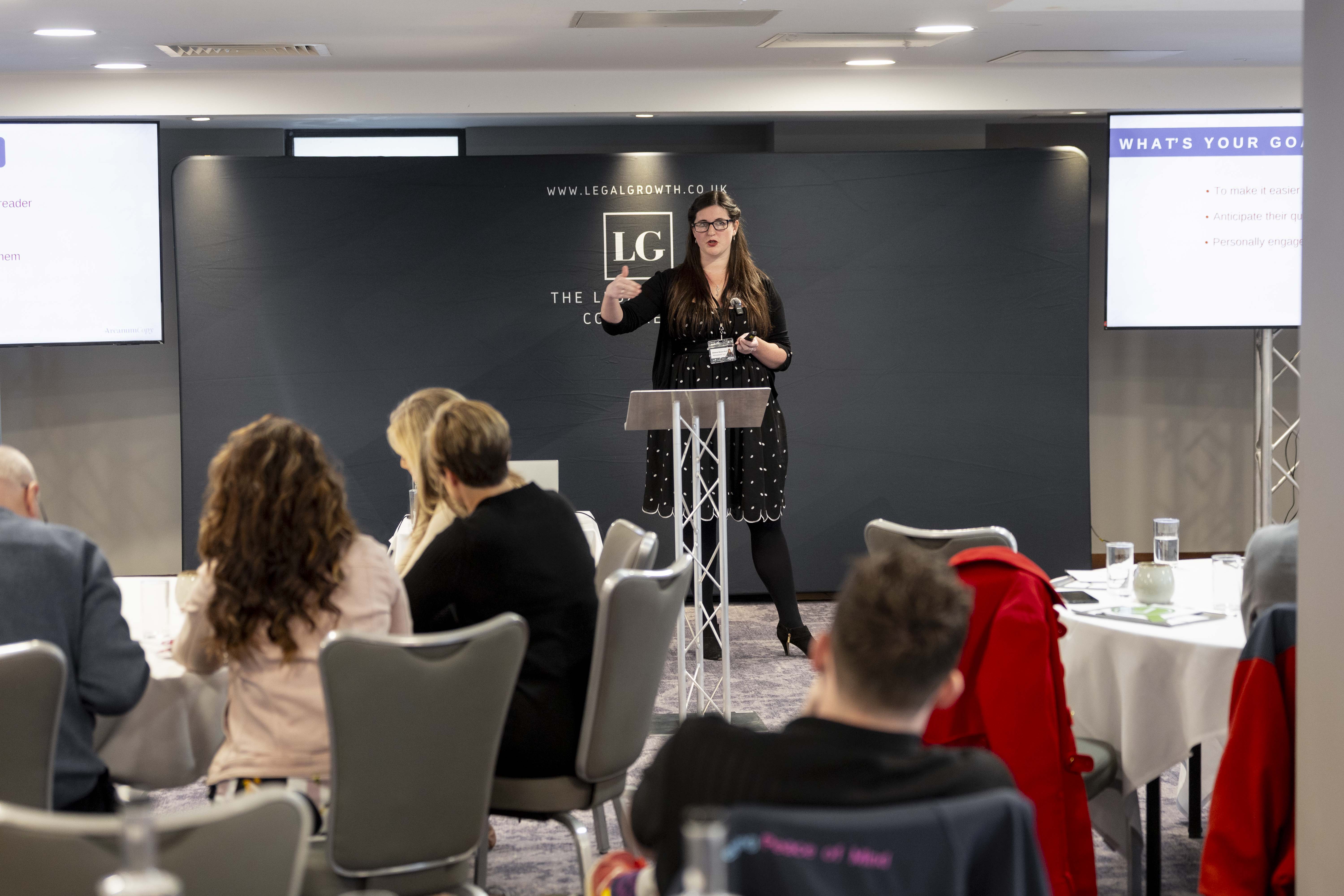 Eleanor Bryan delivering a presentation at a business conference.