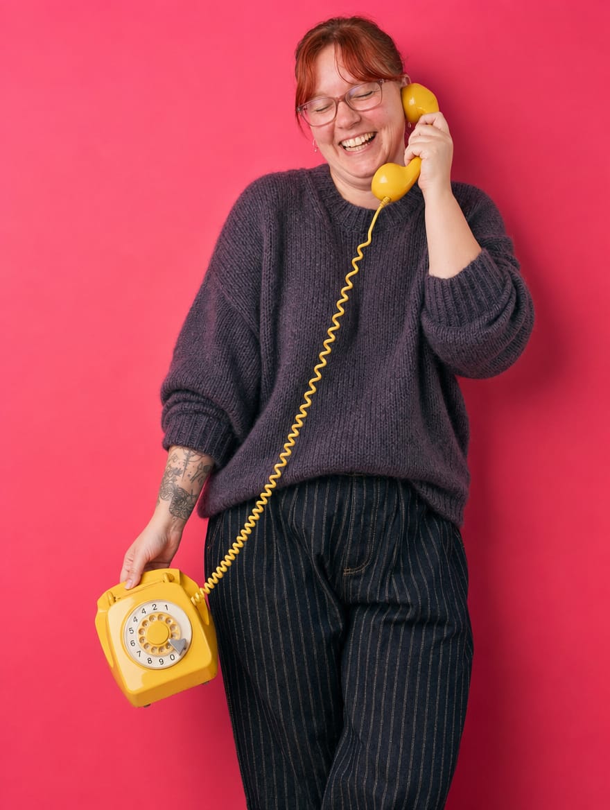 Wendy laughing on a yellow rotary phone
